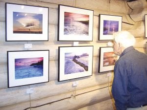 Ben Petz perusing photos in the east room of the Johnson Heritage Post. A photography exhibit featuring seven photographers and many images of the Northwoods opened Friday, March 5, 2010.