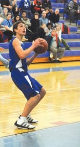 The Cook County boys’ basketball team battled back and forth with the Silver Bay Mariners in the second round playoff game. Left: Sophomore David Bergstrom, pictured here at an earlier home game, had a great all-around game against Silver Bay, scoring nine points, grabbing 13 rebounds, and dishing out three assists. Above: The Vikings tensely listen to the National Anthem, waiting for the game to begin. Right: Senior James Groth added 10 points to the playoff game.