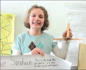 Middle Right: Marin Hay shows her “sandwich quarterer,” which cuts sandwiches in quarters when you push down on the handle. It is made of two cookie cutters, two pieces of grooved wood flooring, a screw and some scrap wood. Above Right: Will Lamb’s “auto coat, hat and mitten dryer” is for days when it is all wet and sloppy outside, or for when you go ice fishing. Warm air is pushed through PVC pipe with special vents that warm and dry your stuff. Above Left: Mariah Deschampe shows off her 