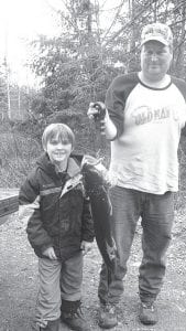 St. Patrick’s Day 2010 was a lucky day for the Sheils family of Grand Marais! Nate Sheils is pictured here with his son Levi and the 35-inch lake trout Levi caught. Right: Little brother Lucas also has a reason to smile. He caught a 32-inch lake trout.