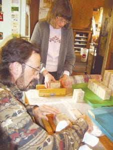 have been making their Superior Herbal soaps on the North Shore for 10 years now. Deb and Steve are pictured on the far left cutting the soap to begin the curing process. On the left are the natural ingredients—solid and liquid oils—that are combined to create the healthy, organic soaps.