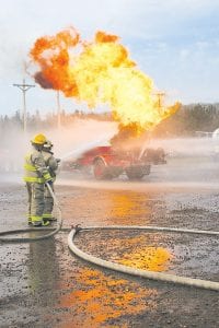 Firefighters practiced approaching and spraying a propane truck engulfed in flames at the Grand Marais Recreation Area on Saturday, April 24, 2010. The simulation was part of the annual Emergency Services conference, which included a gamut of training for local emergency responders, ranging from trauma assessment and tourniquets to traffic control and wilderness transport. Schroeder Fire Chief Phil Bonin and Nick Bonin are on the hose. See more about emergency services training on page A13.