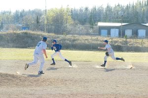 Above: In the Tuesday, April 20 game versus Silver Bay, Jacob Rude attempts to tag a Mariner runner out on his way to third base. Rude lobbed the ball to third for the out. Left: On Thursday, April 22, the Vikings faced the Two Harbors Agates, with Darryl Hansen keeping the Agate hitters off balance the entire game.