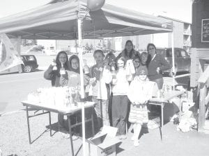 Fourth grade Girl Scout Troop 4117 outside the Whole Foods Co-Op in Grand Marais. They commemorated Earth Day April 22, 2010 by selling eco-friendly cleaning products they manufactured and packaged themselves. (L-R, front) Abby Prom, Wellesley Howard- Larsen, Claire Sherburne, Linnea Gesch, Amelia Roth. (L-R, back) Lucy Callender, leader Jinsey Smith, Daphne Lucina, Kya Brazell, leader Trish Francis.