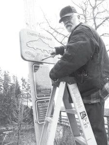 Chuck Berard, maintenance man at Lutsen Resort, puts the finishing touches on the Poplar River Trout Club sign for club founder, Bruce Zimpel. The sign reminds anglers of the 20-inch minimum limit for Coaster Brook Trout. The Minnesota stream trout season opened April 17.