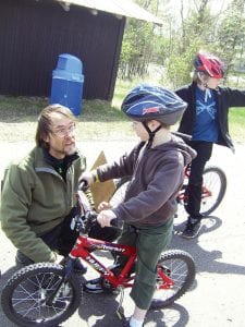 A community Bike Rodeo was held at the Cook County Community Center on Wednesday, May 12. Young bicyclists and family members gathered despite high winds and chilly spring temperatures. Mark Spinler of Superior North Outdoor Center talks to a young bicylist. Spinler adjusted more than 50 bikes for free at the bike rodeo. See more Bike Rodeo photos on page A13.