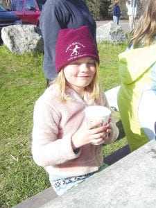 Girl Scout Amelia Roth enjoying some hot chocolate after cleaning up trash along the Kadunce River.