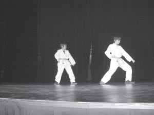 Above: Billy Owens (left) and Kylor Greene demonstrate karate techniques. Right: Samuel Sietsema sings for the audience.