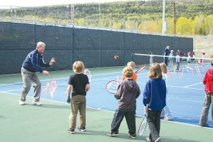 Paul Muus, having as much fun as the kids, instructs children 6-8 years of age how to hit a tennis ball at the Junior League Tennis Association practice.