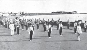 This undated photo shows the Cook County High School Band in full marching regalia in Grand Marais, led by Harold “Ike” Ikola. Note the piles of pulpwood on The Point in the background. Does anyone know what year this was? DlA