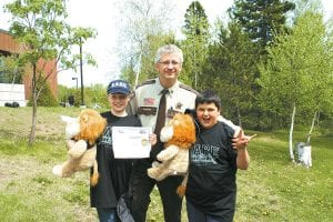 Above: Cook County Chief Deputy and DARE officer Leif Lunde with the students whose essays won them the grand prize— the DARE lion mascot. (L-R) Melanie Smith, Lunde, Douglas Pervais. Left: Lunde was very happy to announce poster contest winners Megan Johnson (left) and Madysen McKeever.