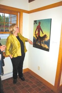 Suzan From peruses an Arnold Friberg painting at Cross River Heritage Center in Schroeder June 4. The exhibit is one of several that visitors can enjoy this summer season.