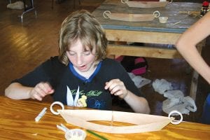 Learning is fun at North House. Area fifth graders learned about boat making at North House Folk School this month. Left: Sarah Gonzales examines her handiwork.