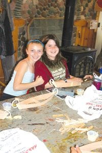 Sarah Toftey and Julia Larsen show off their handiwork at the annual “Bateau” model boat building class held for fifth graders at North House.