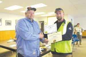 Grand Marais Public Utilities Commission (PUC) Electrical Superintendent Mike Taylor congratulates Lineworker Jeff Eliasen on completion of his apprenticeship. Eliasen is now a Journeyman Power Lineworker.