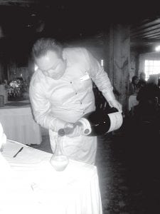 Sommelier Robert McPherson of Lutsen Resort pops the cork on the nine-liter bottle of champagne that was opened at the kick-off event for the resort’s celebration of its 125th year. Nancy Burns of Lutsen Resort explained that the giant champagne bottle is a very special order item and is called a Salmanazar, named after an ancient king of Antiquity.