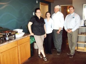 Odyssey Development staff welcomed community members to an open house at East Bay Suites in downtown Grand Marais, now under Odyssey management, on Monday, May 24, 2010. (L-R) Caribou Highlands General Manager Stephanie Slanga, Group Sales Representative Leslie Norman, Moguls Chef Chris Callender, and East Bay General Manager Andrew Norman.