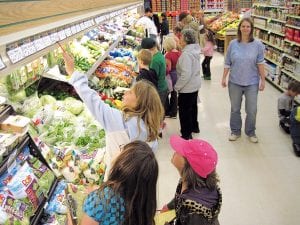 Sawtooth Mountain Elementary School students learned a lot on their walking field trip. Left: Checking produce prices at Gene’s Foods were Halle Bockovich and Alyssa Lashinski-Fenstad with Jessica MacCudden looking on. Above: The second walking field trip was to the Grand Marais State Bank. In front watching the coin sorting, were Alyssa Fenstad-Lashinski, Andrew Miller, Cody Leck, Andrea Larsen, Lance Bartol, and Tristen Bockovich.