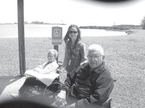 Left: Joyce Kehoe and Earl Anderson with volunteer Bethany Derscheid, waiting in the sun for the Arrowhead Bus after the picnic in the Grand Marais Rec. Park.