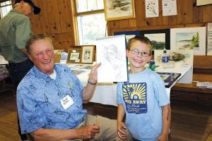 Arts, crafts, and music were the order of the day at the Hovland Arts Festival. After enjoying a delicious fish fry at Trinity Lutheran Church, folks were able to appreciate local artwork. Top: David Hahn and Ray Powell of Taylor Falls, MN and the Arrowhead Trail. This is the third year David has sketched young Ray. Left: Michele Hoy was on hand with beautiful hand-dyed scarves. Above: Many of the artists at the Hovland event use natural materials, like these deer antlers in Terry Lewis’s wind chimes.