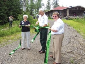 Above: Participating in the ribbon-cutting ceremony at the grand opening of the Chik-Wauk Museum and Nature Center July 4, 2010 were (L-R) museum committee chair and former president Betty Hemstad, Superior National Forest Gunflint District Ranger Dennis Neitzke, and committee historian and current president Susan Kerfoot. Left: Patrick Pierre,member of the Grand Portage Traditional Drum, participated in the ceremonies.