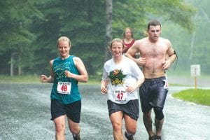 Top: Off they go. At the start of the Tofte Trek 10K Wilderness Run, everyone was nice and clean. Everyone looked much different at the end! Left: The Sentys of Grand Marais—Kelly and Tess and mom, Laurie, just behind—all finished the muddy 10K in under an hour.