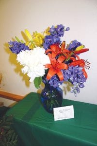 A blue glass vase really sets off this arrangement by Bev Denyes.