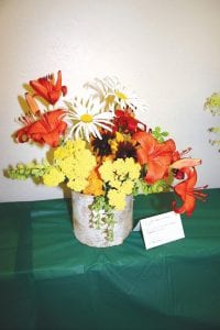 An arrangement by Bette McDonnell of midsummer blooms in a birch bark basket.