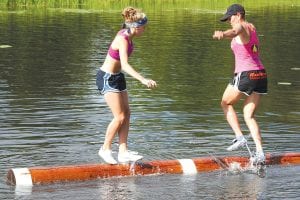 Jenny Atkinson (in pink top) just resumed competing as a professional log roller after battling cancer. Here Jenny is competing at the Namekagon River Roll-Off held two week ago in Hayward, Wisconsin. She lost to this young lady but won her first match. Atkinson is an eight-time world champion and coaches the Cook County North Shore Rollers.