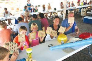 Which card  is going to        win? Families     enjoy bingo        together   at the        American      Legion     bingo tent.