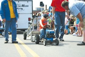 The crowd had as much fun watching as the kids had pulling in the Tractor Pull on Saturday afternoon. Top: Cayden Zimmer, 5, of Grand Marais took first place with this powerful pull. Above: Michael LaTourneau, also 5, claimed second with a smile on his face.