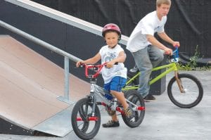 Skateboarders and bicyclists gathered at the North Shore Skate Park in Grand Marais for an entertaining day with 3rd Lair, a professional skateboarding and BMX bike team. Above left: 3rd Lair BMX riders helped kids hone their skills on the ramps at the skate park, which the 3rd Lair declared “the best in the state.” Above right: Austin of 3rd Lair gives Jaymie Kirk, 8½ of Grand Marais, skateboarding tips.