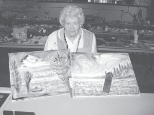 Dorothe Vaughn displays her two-prize winning oil paintings at the Cook County Fair. Residents won 13 ribbons in all at the fair.