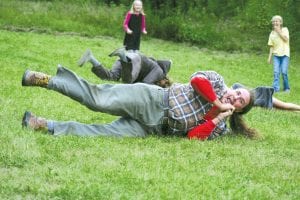 After watching kids roll down the sliding hill, these two fellows decided to join the fun—to the delight of the watching children.