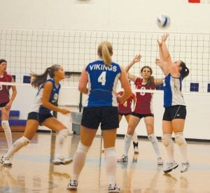 Great start for Viking volleyball! Left: Brea Boomer moves to spike the ball set by Kristina Rude, as Cecelia Olson prepares to assist. Above: Chelsea Sorenson readies for the return, but doesn’t need to—Teresa Morrin and Brea Boomer successfully blocked the Cardinal attempt.