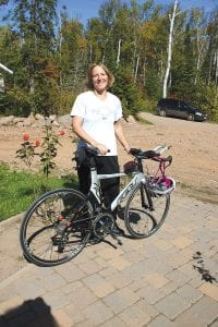 Laurie Senty of Grand Marais with the bicycle she rides when competing in triathlons. Her last competition, the Louisville Ironman race, included a 2.4- mile swim, 112-mile bike ride and 26-mile run. Senty finished the triathlon in 12 hours and 40 minutes.