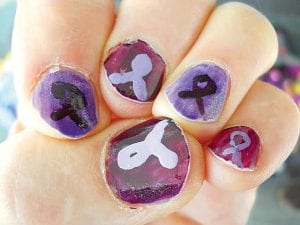 Right: VPC Board Member Denny Fitzpatrick had his nails painted purple, but added an extra touch—a purple ribbon showing solidarity with all who are working to end domestic violence. Fitzpatrick said his nails “are a little rough” but the point is to increase awareness of the problem. Fitzpatrick sadly noted that VPC handles an average of 90 cases every year.