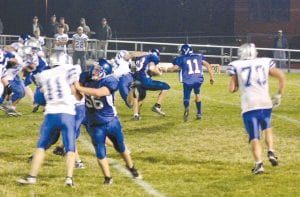 Viking quarterback Kale Boomer (no. 11 in blue) was willing but not able to help his halfback, Peter Warren, as an East Central tackler took down Warren. So far Warren has amassed the sixth most yards of any running back in the conference. The game was played Friday, October 8.