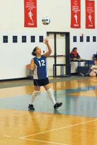 Above: Chelsey Sorenson, who serves as the libero, serves at a recent home game. Right: Sophomore Ali Iverson (front) and Junior Cecelia Olsen are ready for the return.