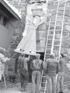 The 14-foot statue of Jesus at the Trinity Lutheran Church in Hovland has been in place since 1949. The statue of Christ is now being restored. Mike Garey, Ken Bjorklund, Floyd Bertelsen, Burt Carlsted-Gillis, and Phil Anderson carefully lower the statue.