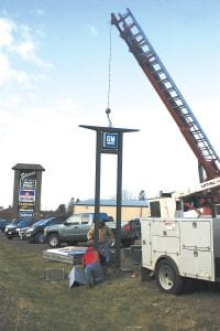 Dave Stickney and Ron Matthew from Mesabi Sign Company of Virginia, MN remove the signpost and the GM/Chevrolet sign at Grand Marais Motors on November 2.