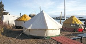 Top: The lakeshore on the North House Folk School campus contained several tents and many more tents were put up in the Grand Marais Recreation area, as several hundred people spent the weekend taking part in the Winterer's Gathering festivities. Many tents contained small wood burning stoves that kept the people in them toasty warm. Left: Tom Dengler was paying meticulous detail to the dragon boat he was carving. Dengler was one of several hundred folks who participated over the weekend. Above: Instructor Fred Livesay (red jacket) gives Dale Koniecki some instructions on the fine art of making snow goggles, while Lisa Mayo (in back) works on her goggles. Koniecki moved from Milwaukee to the Twin Cities three months ago. He said he has been waiting to take this class “for the last three years.” This is not the only class that Koniecki has taken at North House, and he gave the program a big thumbs up.