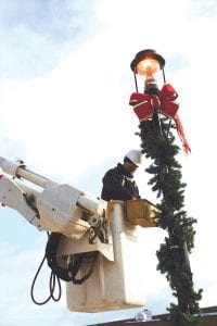 City of Grand Marais lineman Jeff Eliasen is busy putting Christmas decorations on this lightpole by the Joynes Department Store parking lot Thursday, December 2, 2010.