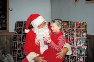 The American Legion Post 413 Auxiliary hosted a children’s Christmas carnival at the legion lounge on Sunday, December 12. Dozens of kids enjoyed a snowman bean bag toss, a lollipop Christmas tree, a dime toss, ice fishing and more. Top: The highlight of the day was the appearance of Santa Claus! Kamryn Johnson shares her Christmas wishes with Santa. Above: Kirsten Pederson helps little Jordan Gotchie with her “catch” in the ice fishing game. Right: There were a number of delicious goodies for the cakewalk and kids enjoyed the trip around and around to find out whether or not they won a cake or pie.