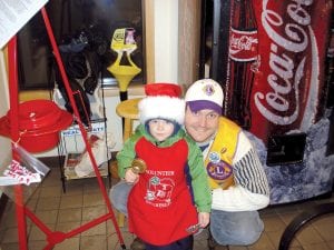 Above: Noah Smith and his dad, Andrew, rang the red kettle bell on behalf of the Grand Marais Lions Club last week. Not many shoppers at Gene’s Foods were able to resist the smiling little boy. He helped them by taking the donations and “putting them in the can.”