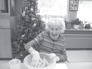 Above: Donna Willett mixing Christmas cookies for the Christmas party. Residents took turns with the baking and made eight dozen Russian Tea Cakes. Left: In December, students from the Sawtooth Elementary “Afterschool Lounge” enjoyed decorating gingerbread cookies and making a candy calendar before the holidays with residents at North Shore Care Center.