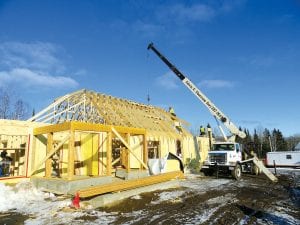 A crane from Edwin E. Thoreson Inc. sets the trusses in place for the new Grand Portage National Monument seasonal staff housing building. The project is being completed through a partnership between the Grand Portage Band of Lake Superior Chippewa and the National Park Service. The building will provide housing for seasonal interpretive staff at the Grand Portage National Monument.