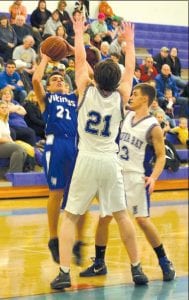 David Bergstrom goes up for two points over 6 foot 3 inch Baruch Fisher (21), and Ryan Thun. Bergstrom scored 18 points in the game—four baskets coming from long range in the game played last Tuesday night at home.