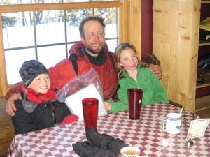 Odin Jorgenson took a break at Devil Track Lake during the John Beargrease Sled Dog Marathon to visit with the students who received the mail he delivered by dogsled, Ethan Sporn (left) and Claire LaVigne.