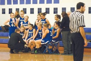 Head Coach T.J. Super outlines a play during a timeout. (L-R, seated) Bekah Laky, Taylor Ryden, Ailee Larson, Brea Boomer and Ashley Deschampe (holding water bottle). (L-R, back) Ali Iverson, Kaitlyn Linnell, Jessica Berg-Collman, Breana Peterson, Theresa Morrin, and Leah Utities.